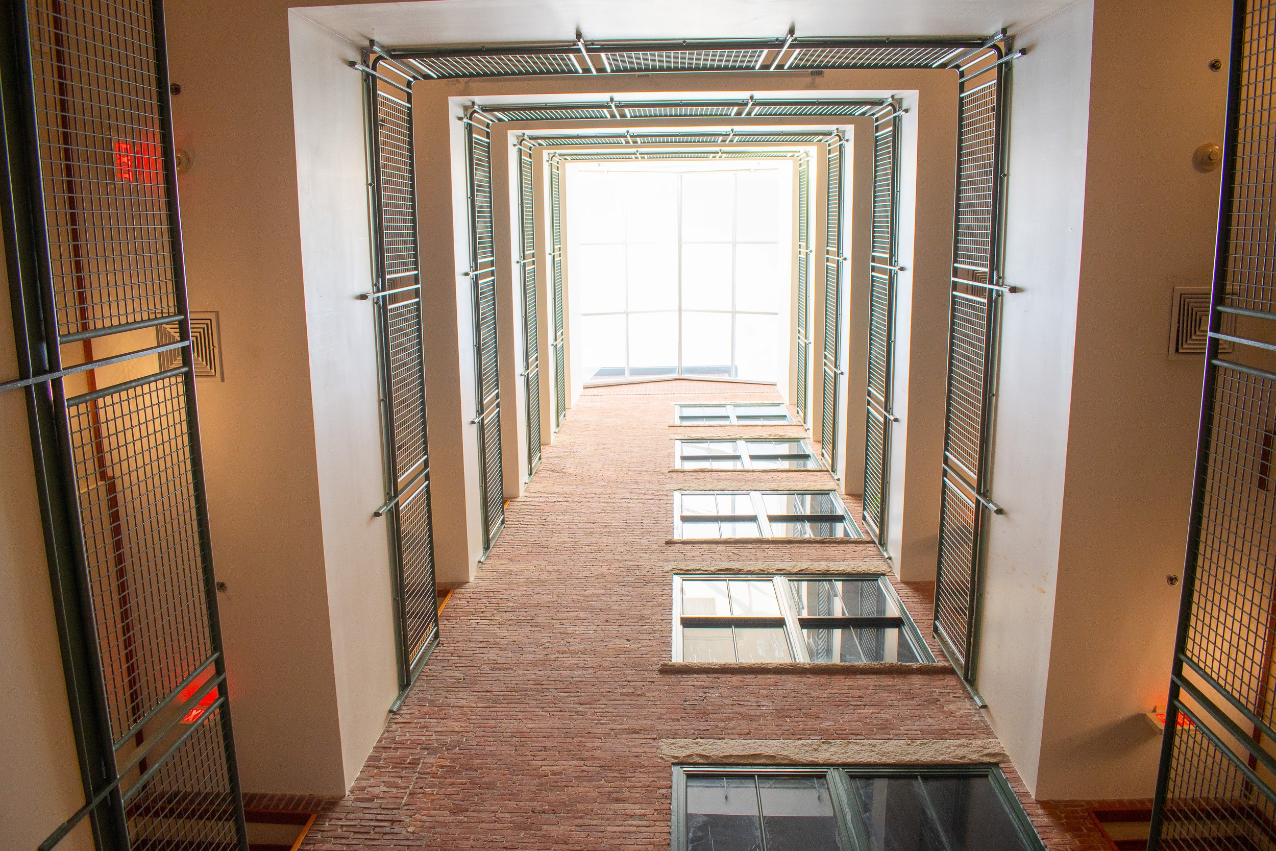 A long hallway with windows on the top floor.
